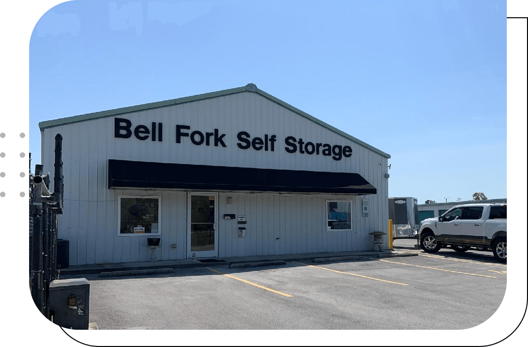 A truck parked in front of a storage building.